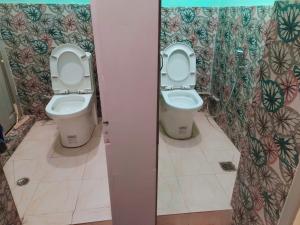 two toilets in a bathroom with two stalls at Heranya hostel in Jawlakhel