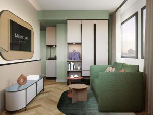 a living room with a green couch and a table at Mercure Milano Agrate Brianza in Agrate Brianza