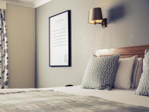 Un dormitorio con una cama con un cuadro en la pared. en Mercure Gloucester Bowden Hall Hotel, en Gloucester