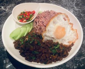a plate of food with an egg and rice and vegetables at Pailin Daily F3 in Phetchabun