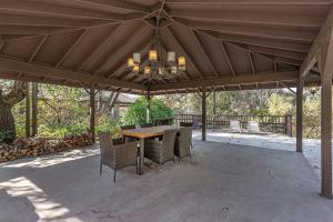 a pavilion with a table and chairs and a chandelier at Sequoia Riverfront Guest House Right On The Water in Three Rivers