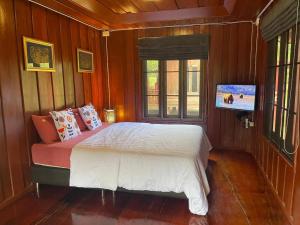 una camera da letto con un letto e una TV a parete di Nai Khun Khao Resort a Chiang Mai