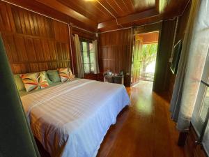 una camera da letto con un grande letto in una camera in legno di Nai Khun Khao Resort a Chiang Mai