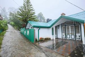 ein kleines Haus mit einem grünen Dach in der Unterkunft Peak View Cottage in Nuwara Eliya