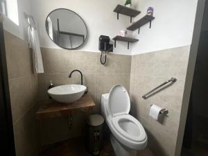 a bathroom with a toilet and a sink and a mirror at Casa Don Beni in Xicotepec de Juárez