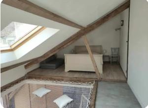 a loft conversion with a bed and a window at L'atypique in Lignières