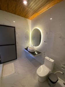 a white bathroom with a toilet and a sink at The Village Agonda in Agonda