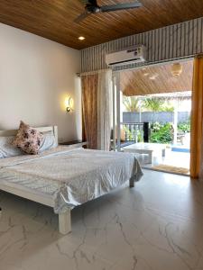 a bedroom with a bed and a large window at The Village Agonda in Agonda