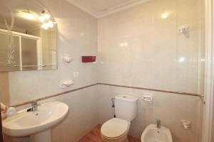 Un baño con un inodoro blanco y un lavabo. en Apartamento Tenerías Gruta by SIERRA VIVA, en Aracena
