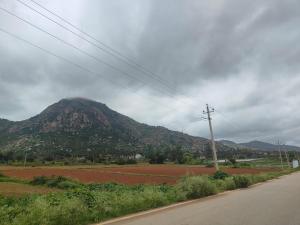 een berg in de verte met een weg op de voorgrond bij Nandi Parihar Villa 1 in Bangalore