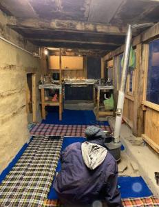 a room with a person sitting on the floor at Mirvana home stay in Kalgha