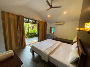 a bedroom with a bed and a ceiling fan at The Village Agonda in Agonda