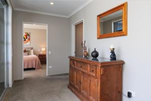 a bedroom with a dresser and a mirror on the wall at picton beach view apartment in Picton