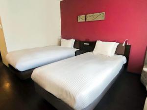 two beds sitting next to each other in a room at HOTEL AMANEK Osaka Namba in Osaka