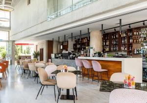 Un restaurante con mesas y sillas y un bar. en Elysia Park Sanara Holiday Apartments, en Pafos