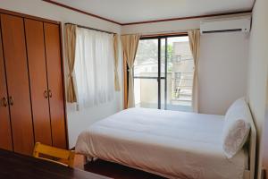 a bedroom with a bed and a large window at Akira Hiro House - Room202 in Tokyo