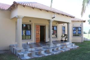 a house with a staircase leading to the front door at Black Horses Lodge & Conferencing in Vryheid