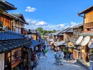 a street in an old town with people walking down it at RESI STAY Kuon in Kyoto