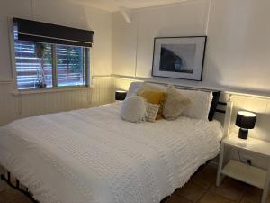 卡尔巴里Manta Stays Resort-Style Tropical Oasis的卧室里有一张白色的床，配有枕头和一扇窗户