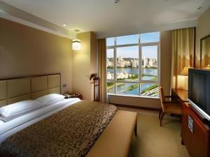 a hotel room with a large bed and a large window at Xiamen Fortune Hotel in Xiamen +275 photos