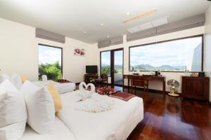 a bedroom with two beds and a desk and windows at Luang Prabang View Hotel in Luang Prabang