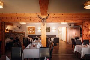 a restaurant with white tables and chairs and a deer head on the wall at Hotelanlage Starick in Lübbenau