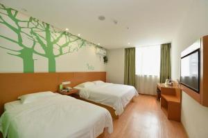 a hotel room with two beds and a flat screen tv at Vatica HeFei Baishuiba BHG Hotel in Hefei +285 photos