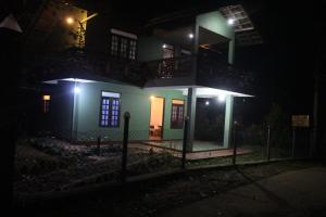 a house lit up at night with lights at rainforest river song 