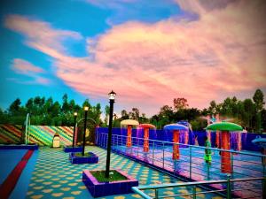 a park with a pool with colorful water play equipment at Mukta Nagar Resort in Pitua