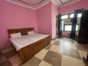 um quarto com uma cama em um quarto com paredes rosa em Hotel O KK em Haldwani-cum-Kathgodam