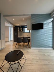 ディナールにあるAppartement central cosy à Dinardのテーブルとキッチンのあるリビングルーム