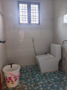 a bathroom with a toilet and a bucket at Top hill home stay in Sāma