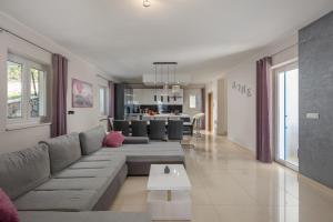 una sala de estar con un sofá y una mesa en Sea View Villa Luka with Pool, en Viskovići