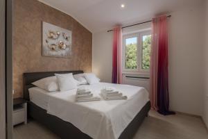 Un dormitorio con una cama con dos toallas encima. en Sea View Villa Luka with Pool, en Viskovići 41 fotos más