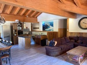 a living room with a couch and a kitchen at Les gémeaux- Plagne 1800- 100m des pistes- sauna privatif in La Plagne Tarentaise