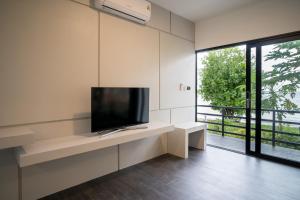 a living room with a flat screen tv on a wall at Pine Bungalow Krabi in Klong Muang Beach