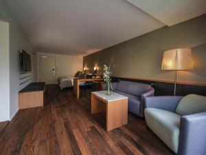 a living room with a couch and a table at Royal St. Georges Hotel Interlaken - MGallery Collection in Interlaken