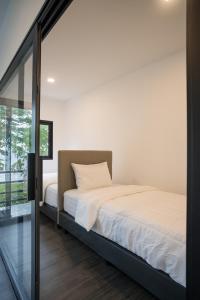 Un dormitorio con una cama y una puerta corrediza de vidrio. en Pine Bungalow Krabi, en Klong Muang Beach