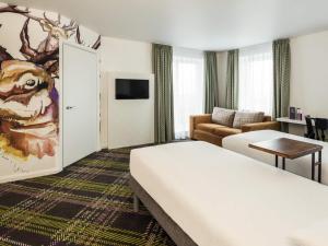 Una habitación de hotel con una cama y una sala de estar. en ibis Styles Edinburgh St Andrew Square, en Edimburgo