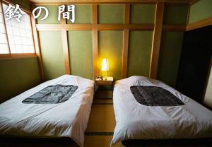 two beds sitting next to each other in a room at 鈴籠城 鈴の間 in Nagahama