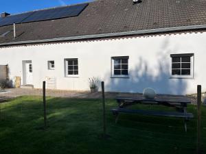a picnic table in front of a white building at Am Conradhof 2 in Louisendorf