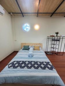 una camera da letto con un letto grande in una stanza di วาคุมิคาเฟ่&โฮมสเตย์ WakumiCafe&Homestay a Ban Pong