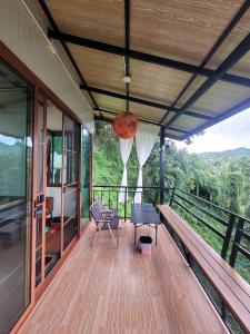 una veranda di una casa con panchina su un ponte di วาคุมิคาเฟ่&โฮมสเตย์ WakumiCafe&Homestay a Ban Pong