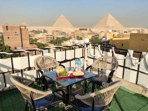 a table with a plate of food on a balcony with pyramids at LOAY PYRAMIDS VIEW in Cairo