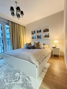 a bedroom with a white bed and a large window at Apartament Kaszmirowy in Grudziądz