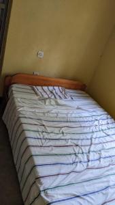 1 cama no hecha en una esquina de una habitación en Akagera Homestay Experiences, en Rwinkwavu