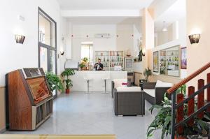 a man is standing at a counter in a store at Sporting Hotel Stella Maris in Bosa Marina