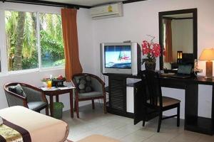a living room with a desk with a tv and a deskictericter at The Nice Patong Hotel in Patong Beach