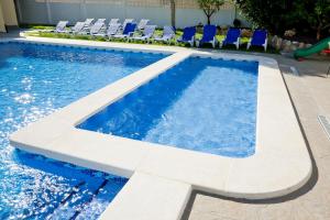 a pool with chairs and a slide in a resort at Ona Aldea del Mar in Torrevieja +19 photos