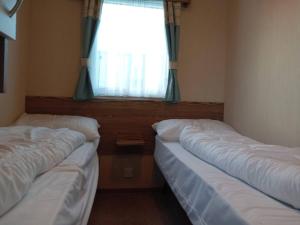 two beds in a room with a window at Beautiful van, beaches, accessible pet friendly in Budleigh Salterton +9 photos